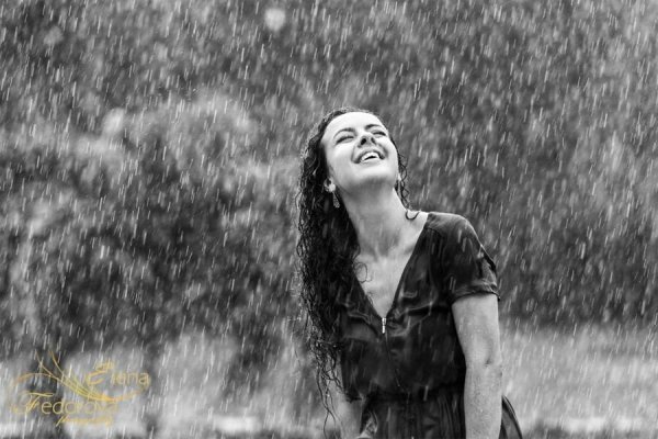 Счастливая девушка под дождем