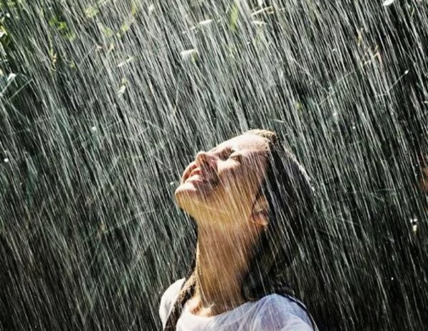 Счастливая девушка под дождем