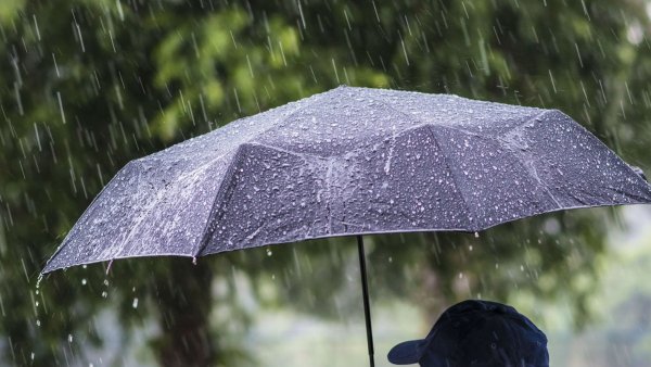 Человек с зонтом под дождем