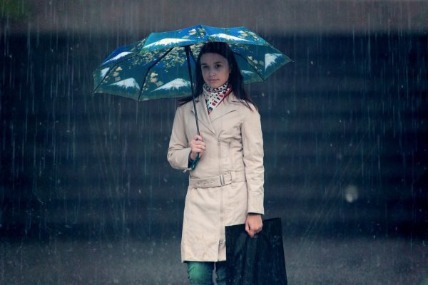 Человек с зонтом под дождем