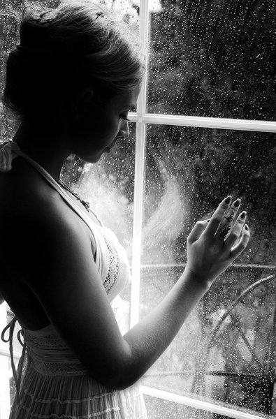 Женщина плачет у окна