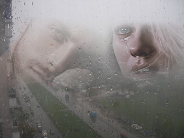 Девушка плачет у окна дождь