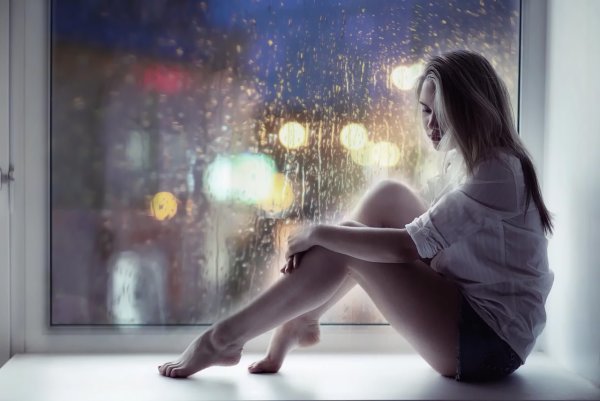 Девушка грустит на подоконнике