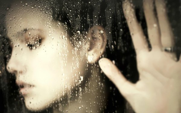 Девушка за стеклом с капельками