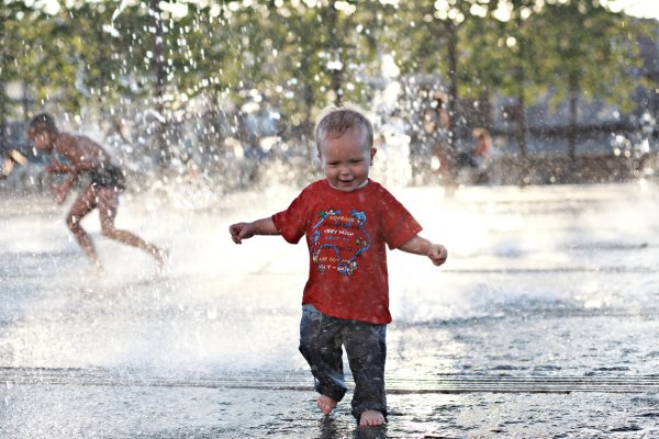 Дети летом бегают по лужам