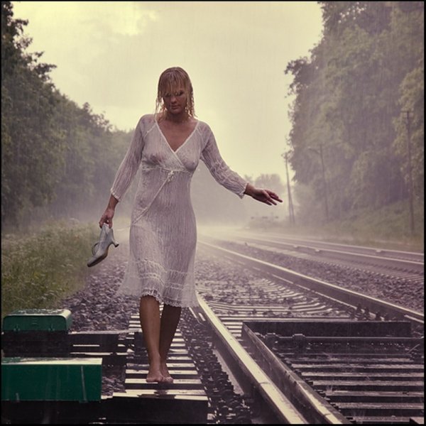 Девушка бежит по рельсам