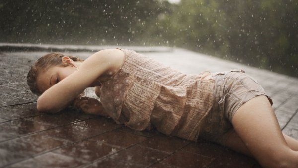 Девушка лежит под дождем