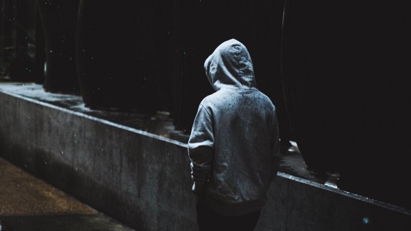 Человек в капюшоне сидит