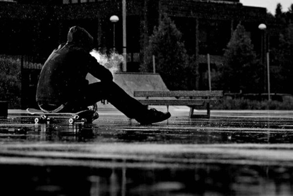 Парень сидит под дождем