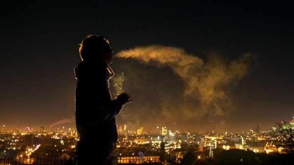 Курит на крыше ночью