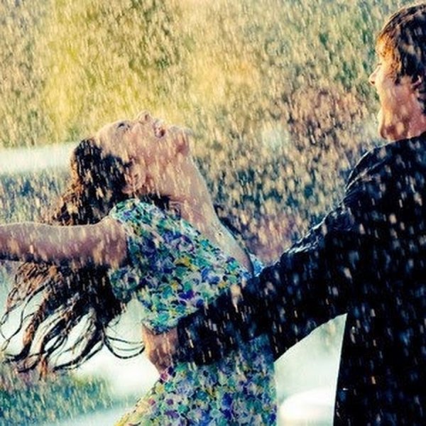 Парень и девушка танцуют под дождем