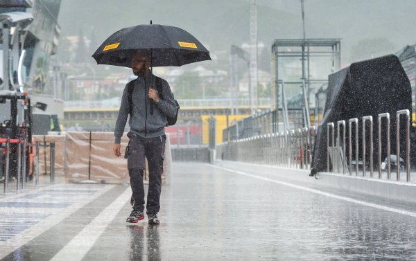 Мужчина с зонтом под дождем