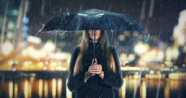 Человек с зонтом под дождем