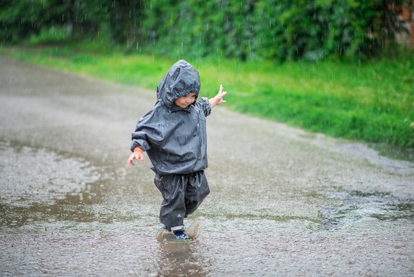 Мальчишки бегают по лужам