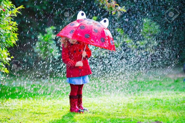Маленькая девочка с красным зонтиком под дождем