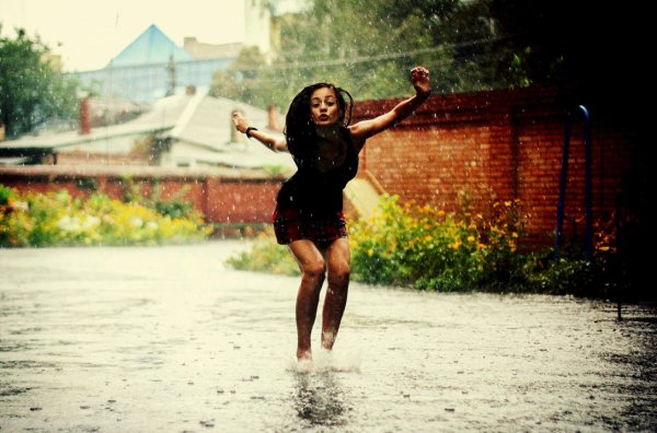 Счастливая девушка под дождем