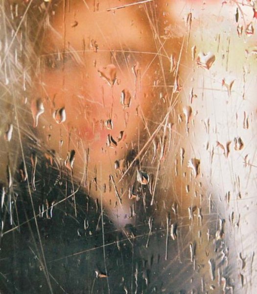 Девушка за стеклом с капельками