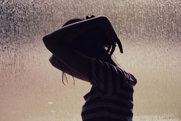 Брюнетка под дождем со спины