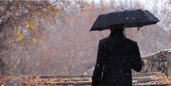 Мужчина в плаще под дождем