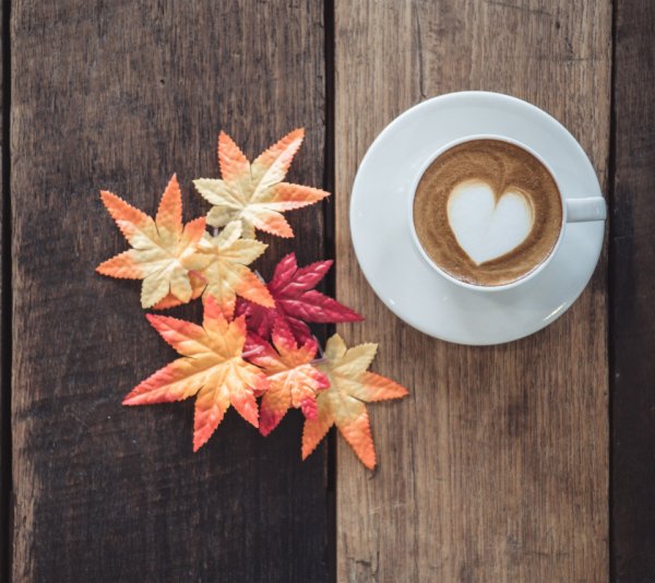Чашка кофе на столе листья осенние