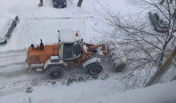 Трактор чистит снег