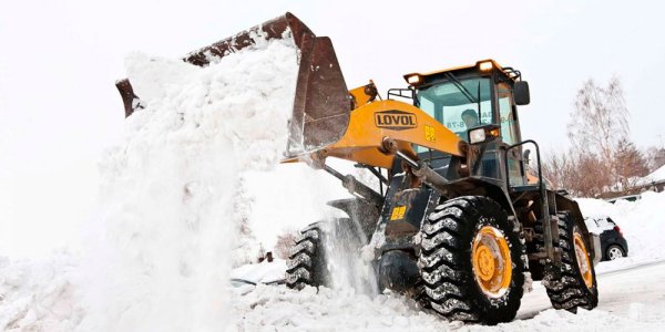 Трактор JCB убирает снег