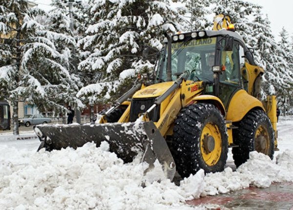 Трактор JCB убирает снег