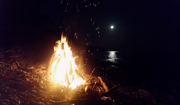 Костер на берегу моря ночью