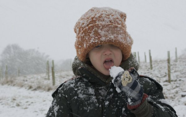 Мальчик ест снег