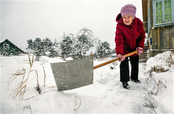 Женщина убирает снег