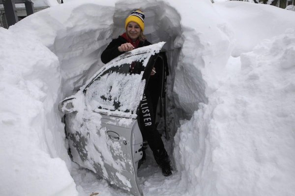 Откапывает машину из снега