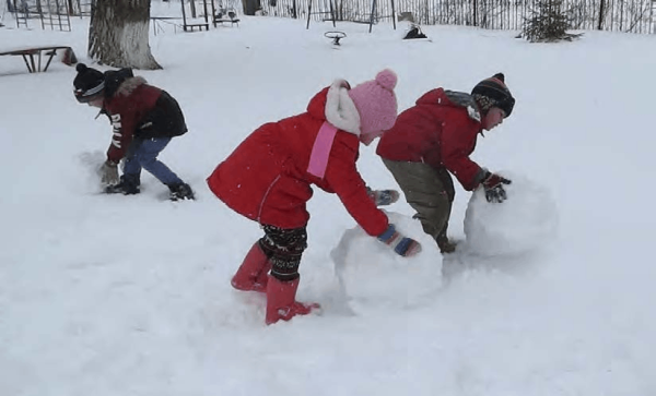 Дети катают снеговика