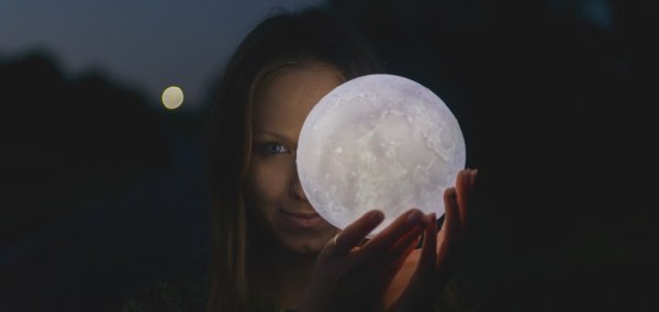 Девушка держит в руках луну