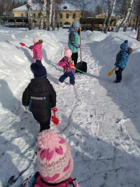 Разбрасывание снега на участке детского сада