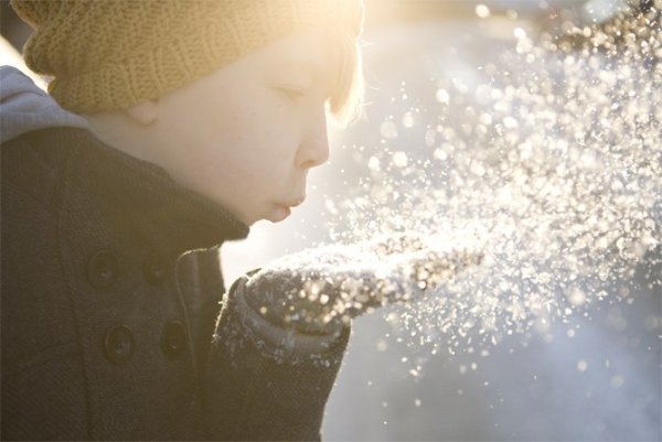 Ребенок сдувает снег