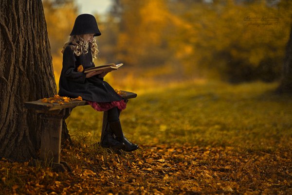 Девушка в осеннем саду с книжкой