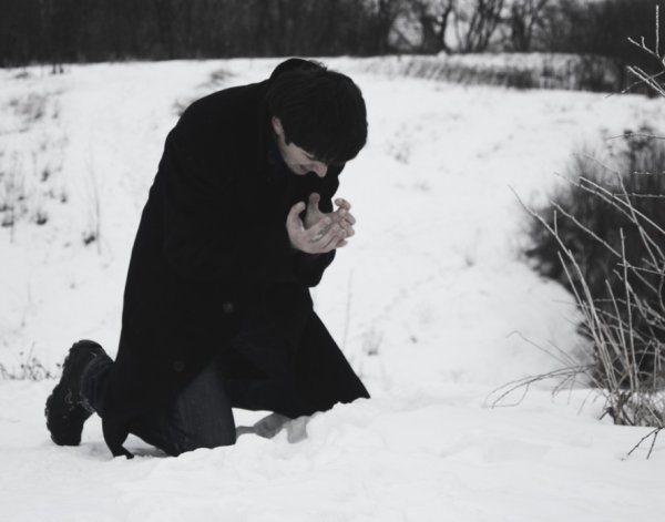 Парень сидит на снегу