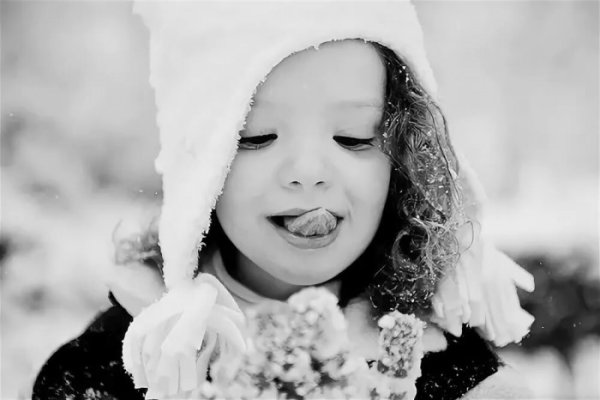 Девочка ловит снежинки языком