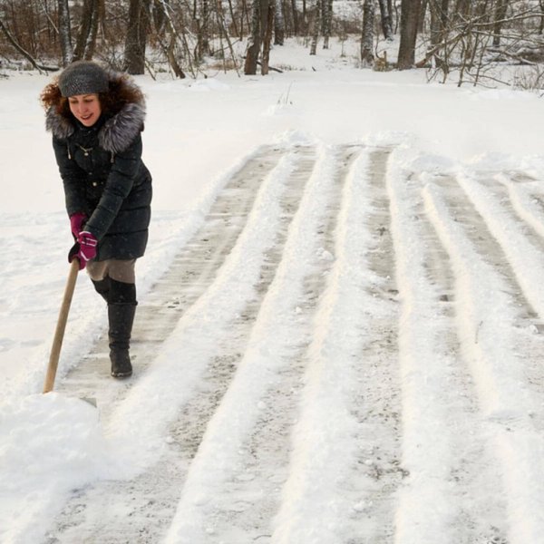 Девушка убирает снег