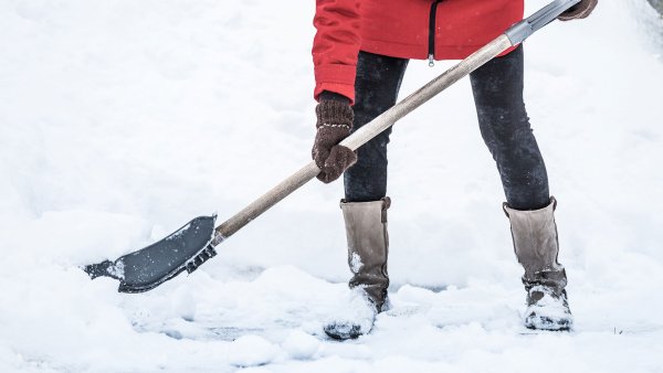 Женщина убирает снег