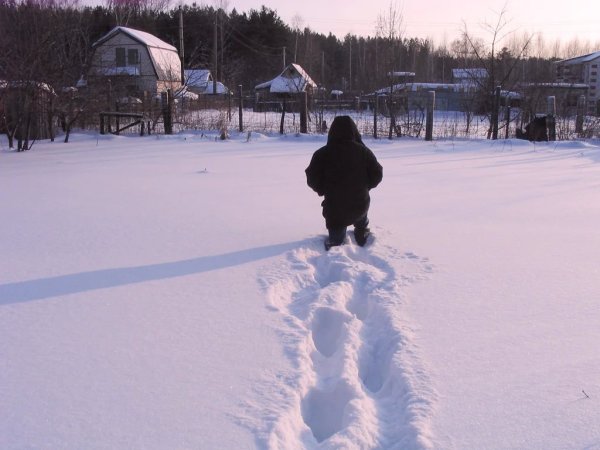 Человек идет по сугробам