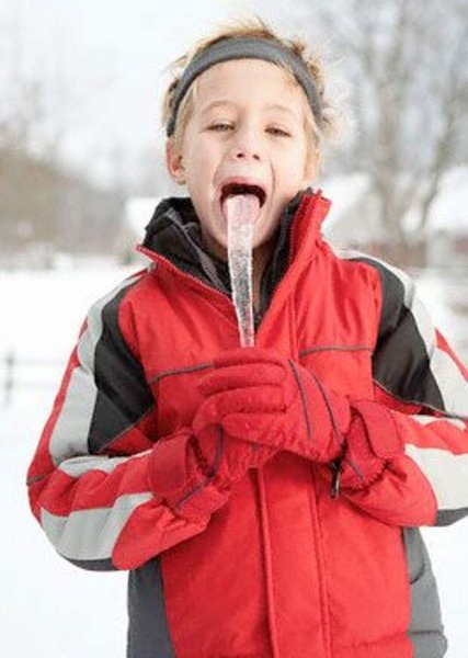 Мальчик ест сосульку