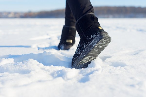 Ноги в валенках идут по снегу