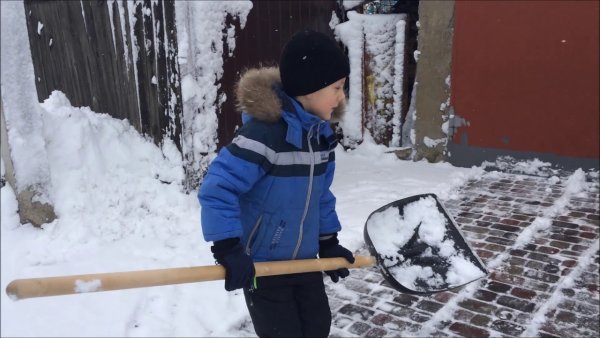 Мальчик расчищает дорожку от снега