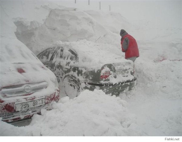 Откапывает машину из снега
