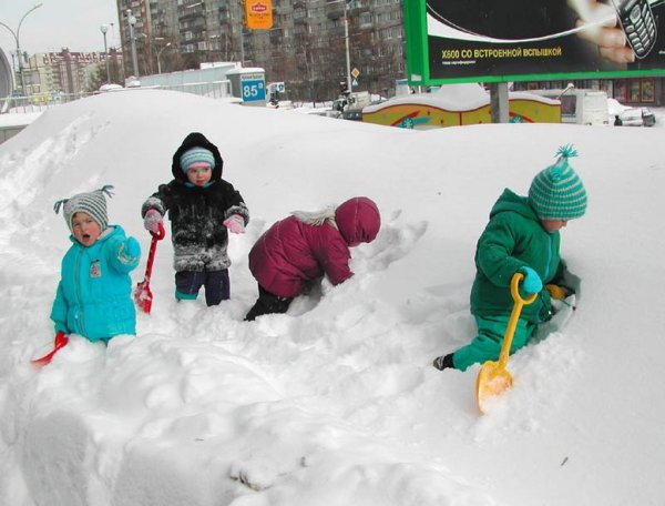 Дети копают снег в саду