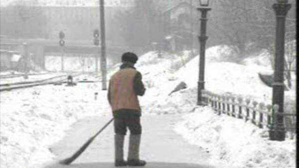 Дворник метет улицу зимой