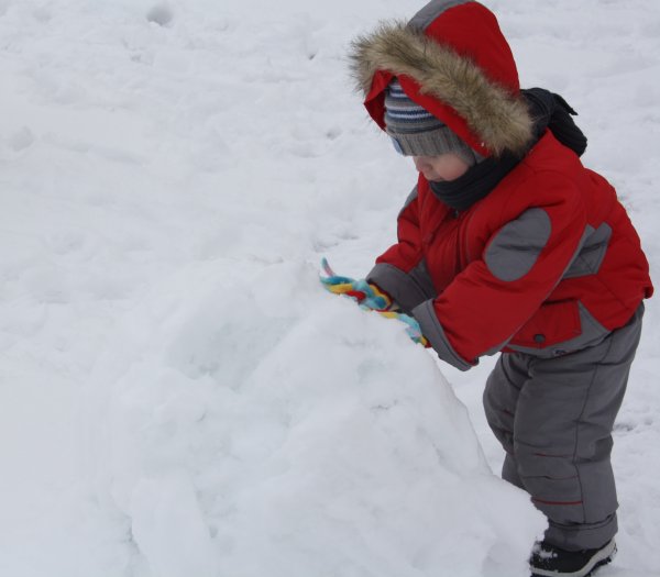 Мальчик лепит снеговика