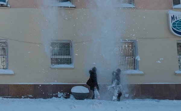 Снег падает с крыши на людей