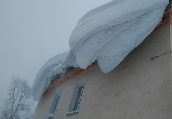 Снег свисает с крыши